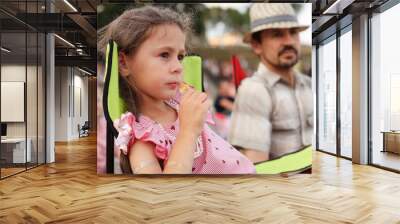 Dad and daughter are sitting in camping chairs at an open-air music festival Wall mural