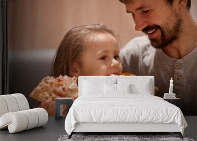 father feeding his cute daughter with pizza Wall mural