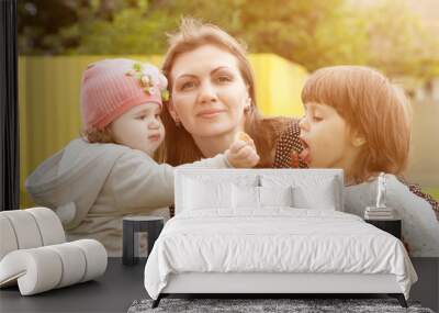 Happy loving family. Mother and her daughters children girls playing and hugging. Wall mural