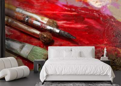 Paintbrushes closeup, artist palette and multicolor paint stains Wall mural