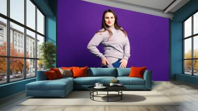 Plus size model in sportswear, fat woman on purple background Wall mural