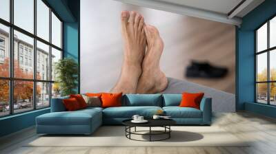 Tired man resting after work at home, male feet, body care concept Wall mural