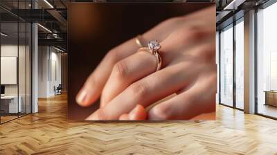 Close up of an elegant engagement diamond ring on woman finger. love and wedding concept. Diamond ring on young lady's hand on dark background. High quality photo Wall mural