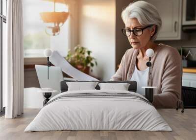 Middle aged senior woman sit with laptop and paper document. Pensive older mature lady reading paper bill pay online at home managing bank finances calculating taxes planning loan debt pension payment Wall mural