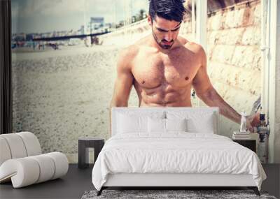 Athletic young man taking a shower on the beach in Nice, France on the French Riviera Wall mural