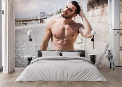 Athletic young man taking a shower on the beach in Nice, France on the French Riviera Wall mural