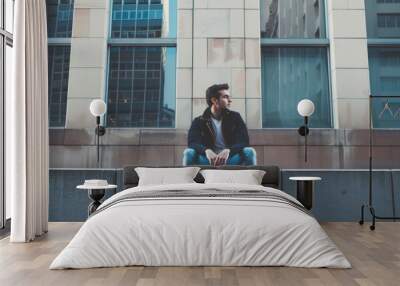 A man sitting on a ledge in front of tall buildings, AI Wall mural