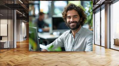 A man smiling while sitting at a desk in front of computer, AI Wall mural