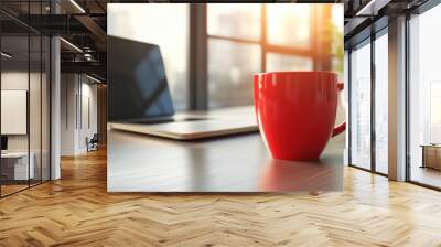 A red coffee cup sitting on a table next to an open laptop, AI Wall mural