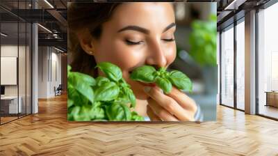 A woman smelling basil leaves in a kitchen with green plants, AI Wall mural