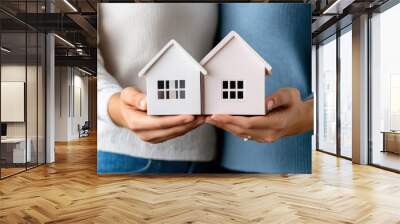 Two people holding small houses in their hands, AI Wall mural