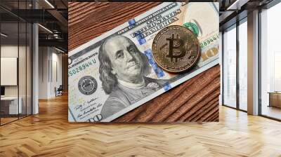 Golden bitcoin and dollars on wooden background. A symbolic coins of bitcoin on banknotes of one hundred dollars. Exchange bitcoin cash for a dollar. Wall mural