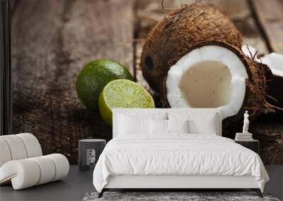 Close-up of split coconut and fresh lime on wooden background. Concept of organic nutrition and dieting.  Wall mural