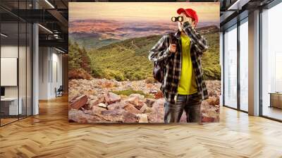 Man finder with binocular standing on stones Wall mural