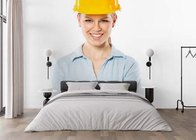 Portrait of smiling woman engineer wearing yellow helmet Wall mural