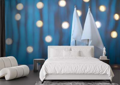 Two white flags stand against a blurred background of glowing lights Wall mural