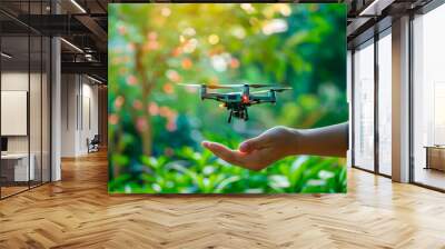 Hand launching a drone in a lush green setting, symbolizing the intersection of technology and nature exploration. Artificial intelligence in quadcopters. Banner. Copy space Wall mural