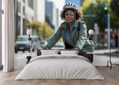 Cycling commuter - a middle aged beautiful African American woman riding a bicycle on a road in a city street. Wall mural