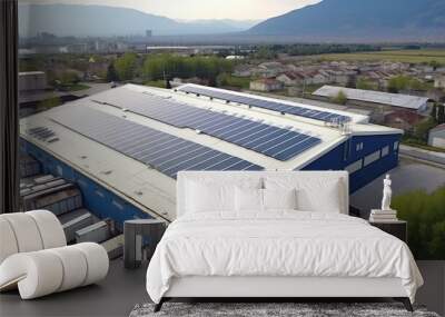 Solar panels installed on a roof of a large warehouse or industrial building. Industrial buildings in the background. Aerial view. Wall mural