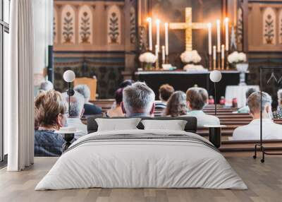 Holy mass in Christian church during the coronavirus pandemic Covid-19. Safe personal distance with protective masks. Wall mural