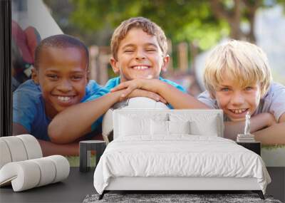 A winning team of best friends. Three happy boys lying outside in the sun with their soccerball - copyspace. Wall mural