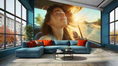 A young Caucasian beautiful adult woman or girl, brunette, passenger enjoying a sunny drive on the road, highway, inside a car while on a vacation or journey, wind through her brown hair. Wall mural