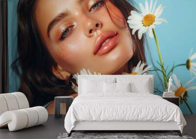 Beautiful woman with long dark hair is holding daisies flowers in a beauty concept Wall mural