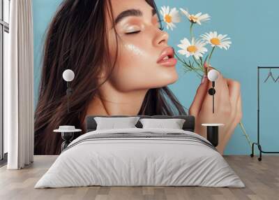 Beautiful woman with long dark hair is holding daisies flowers in a beauty concept Wall mural