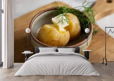 a ceramic bowl containing a boiled potato with butter and fresh dill Wall mural