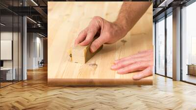 Mans hand on sanding block on pine wood Wall mural