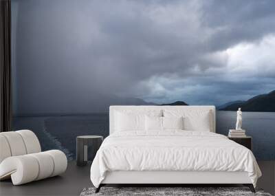 Rain over the mountains as cruise ship sails through the fjords of Chile and Patagonia Wall mural