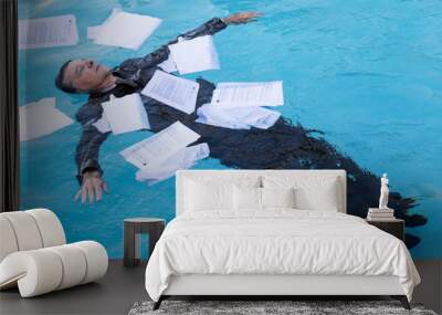 Senior man floating among papers in water Wall mural