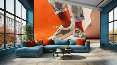 A man is wearing a pair of white shoes and orange socks Wall mural