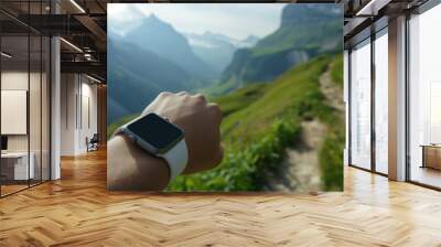 A person is wearing a watch and pointing at the mountains Wall mural