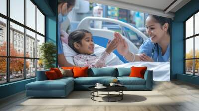 woman nurse or medical staff give a high five to little girl patient Wall mural