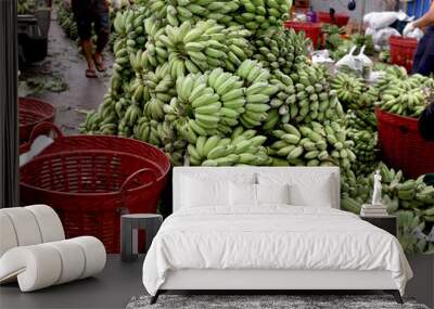 A lots of green cultivated bananas on floor after the harvest. Fresh sweet sugar bananas from agriculture farm are taken to the market for sale. Pisang Awak banana Wall mural