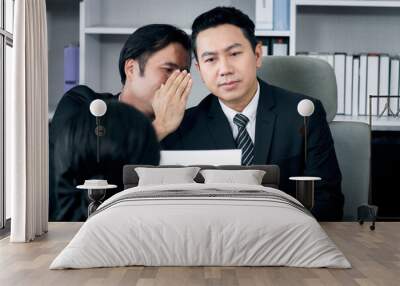 Businessman colleague whispering secret gossip into his partner during meeting, people with interesting gossip and rumor in office workplace. Wall mural