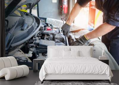 Hands of auto mechanic worker man checking engine, technician working in garage, car service technician repairing customer car vehicle, inspecting engine system at automobile repair service. Wall mural