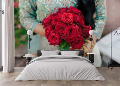 Afghani bride's holding a wedding bouquet of red roses close up Wall mural