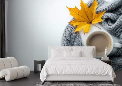 A fall themed setup with a cup of coffee cozy scarf and a yellow maple leaf on a white backdrop providing a blank area for text. Creative banner. Copyspace image Wall mural