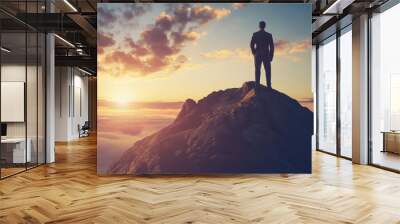 a man stands on the mountain and looks at the sunrise, business clothes , motivation for success, coach, personal growth Wall mural