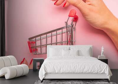 hand with shopping cart isolated on white Wall mural