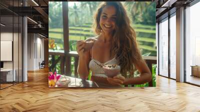 Beautiful woman eating a smoothie bowl in Bali Wall mural