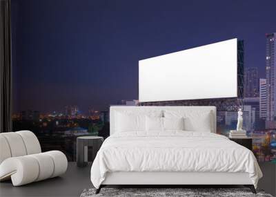 Billboard with with white blank on a cityscape by night. Blank on the left in the sky for your message or logo Wall mural