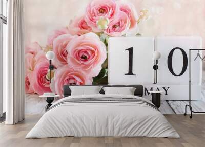 White wood calender blocks and pink ranunculus flowers with the date May 10 th for Mother's Day. Selective focus with blurred background. Wall mural