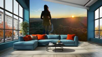 Person on the top of a mountain. Woman looking at the sunset over the blue mountains, Sydney, Australia, NSW. Spectacular view from a lookout. Hiking to see the sunrise over a grand canyon. Wall mural