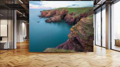 Coastal landscape of the red sandstone Seaton Cliffs during sunset or sunrise at Arbroath east coast of Angus, Scotland. Wall mural