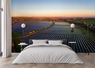 Aerial drone view of solar panels at a solar energy generation farm at Sunset in South Wales, UK Wall mural