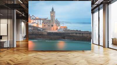 Moody, atmospheric night view of the pier and church clock tower at the quaint seaside village of Porthleven, Cornwall, England, UK. Wall mural