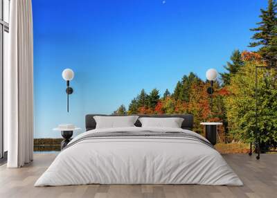 View of shoreline and beach around a lake in autumn, Nova Scotia, Canada. Trees in fall colors. Reflection in the water's surface. Wall mural